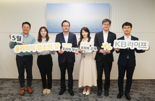 이환주(왼쪽 세 번째) KB라이프생명 대표이사 사장과 표어 공모전 수상자인 김태연 매니저(왼쪽 네 번째), 권성안 준법감시인(왼쪽 다섯 번째), 강동우 준법지원부장(왼쪽 여섯 번째)을 비롯한 준법감시담당 직원들이 지난 23일 서울 강남구 KB라이프타워에서 기념촬영을 하고 있다. <KB라이프 제공>